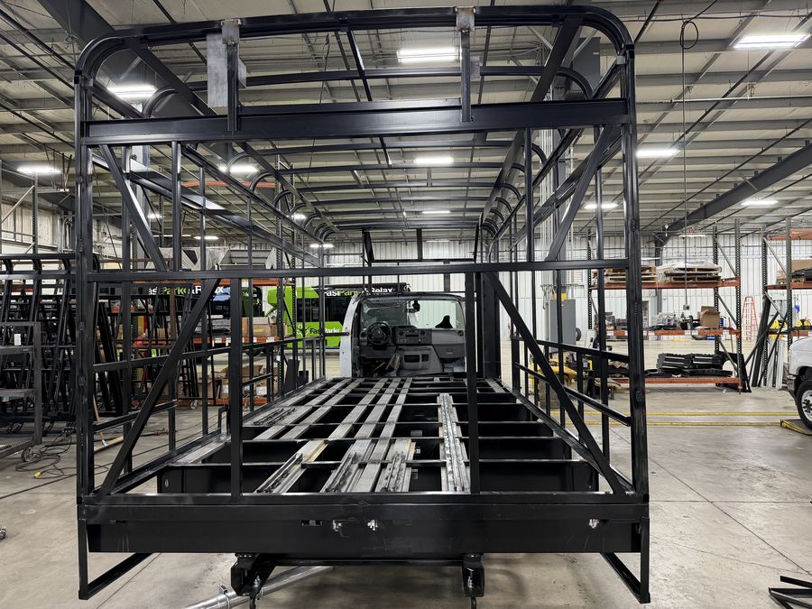 Welded, powder-coated steel-cage bus frame during construction at the HLE plant