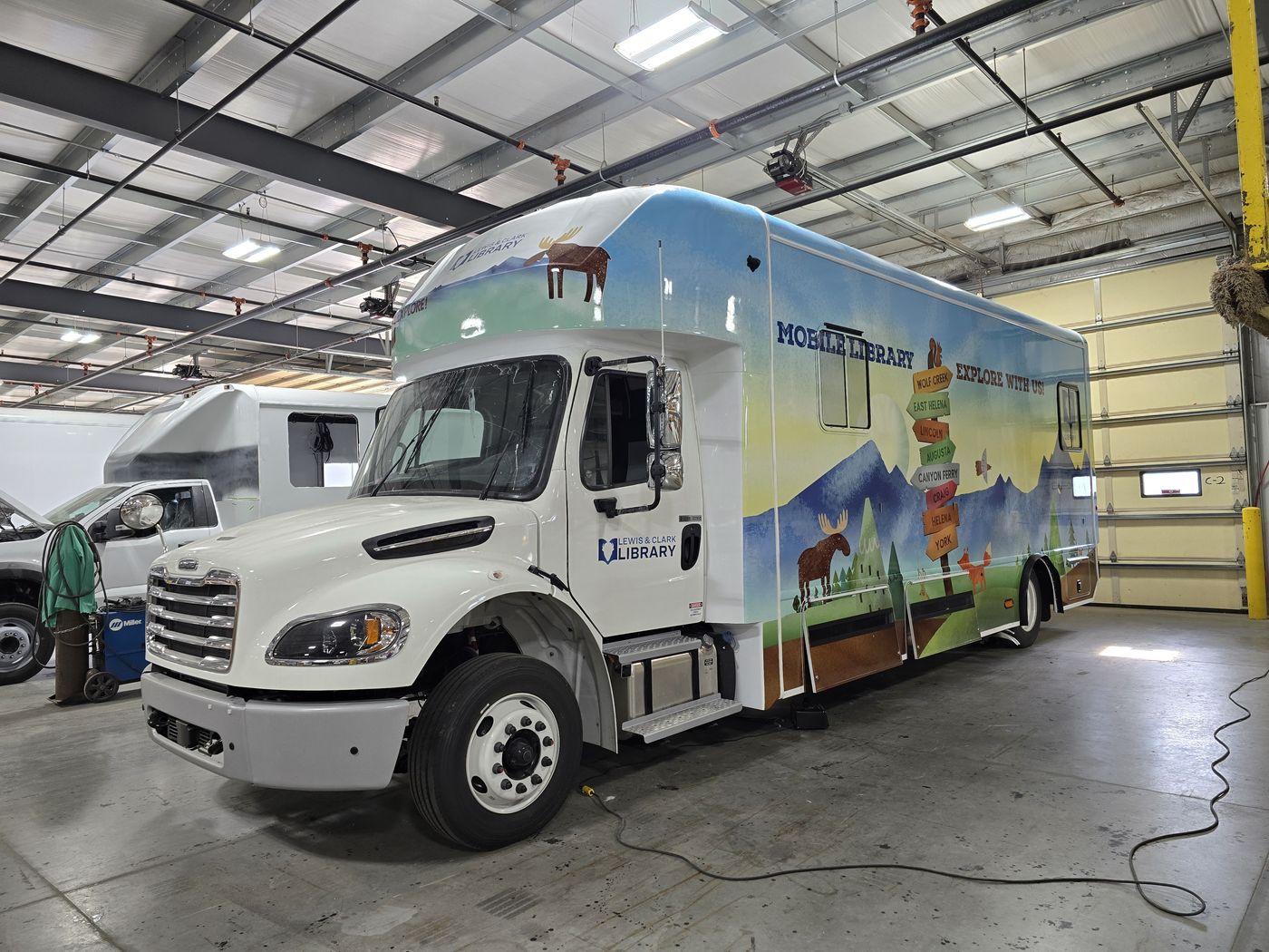 Fully wrapped mobile library outreach vehicle built by HLE on a Freightliner chassis