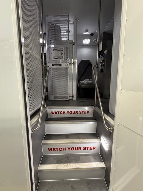 Secure transport bus interior entry with compartment door
